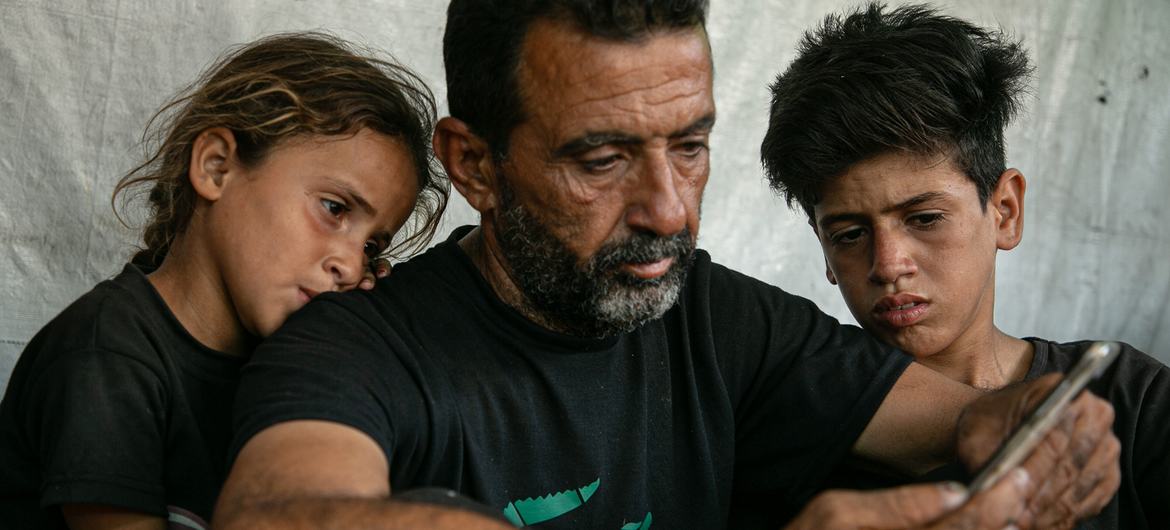 Un père et ses deux enfants se souviennent d’un membre de leur famille tué par un sniper à Gaza.
