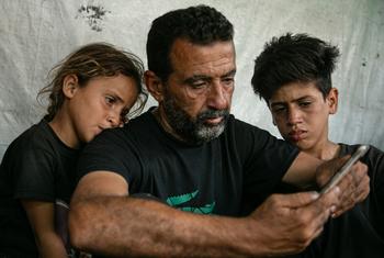 一名父亲与他的两名孩子正在悼念在加沙被狙击手杀害的家人。