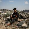A young man sits atop the rubble of a home in Gaza. Basic services including healthcare and clean water are increasingly difficult to provide, say UN aid agencies.