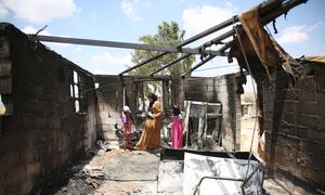 A mother and her children go through their belongings after a room in their home was burned in a settler attack in southern Hebron, West Bank. (July 2025)