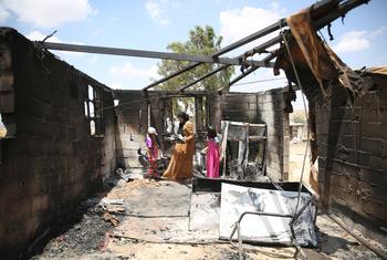 A mother and her children go through their belongings after a room in their home was burned in a settler attack in southern Hebron, West Bank. (July 2025)
