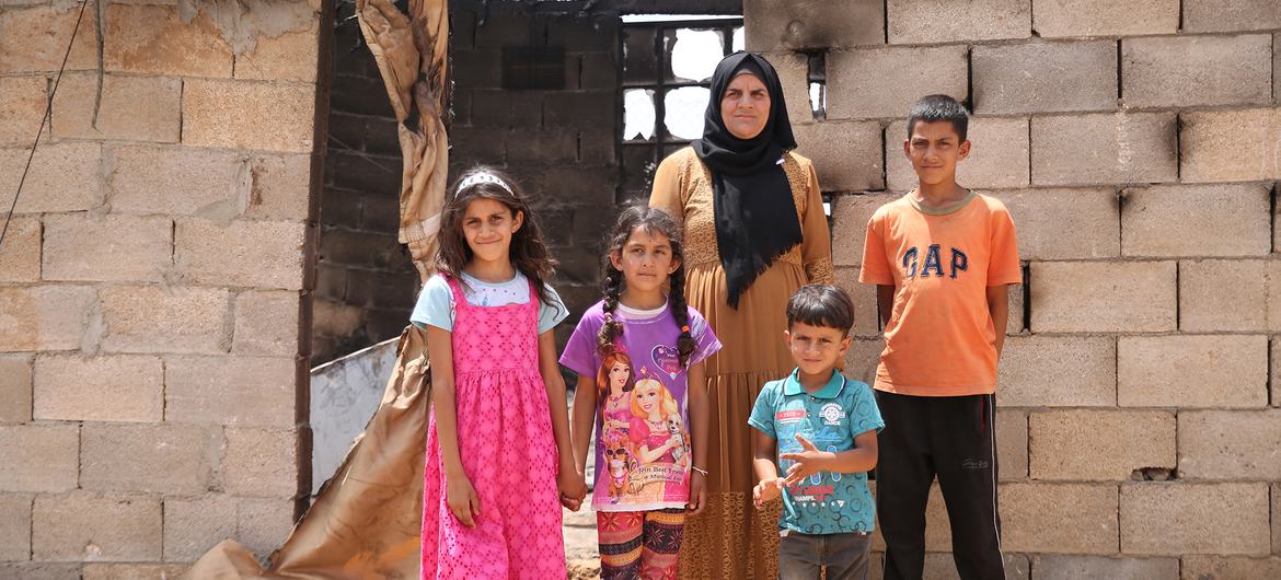 A Palestinian family stands outside their home in southern Hebron, in the West Bank, that was burned in a settler attack.