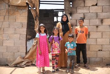 A Palestinian family stands outside their home in southern Hebron, in the West Bank, that was burned in a settler attack.