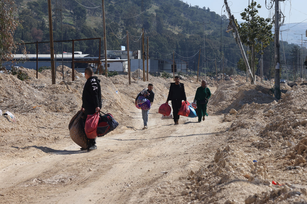 Des familles et des enfants palestiniens transportant leurs biens alors qu'ils évacuent leurs maisons dans le camp de réfugiés de Nur Shams, près de Tulkarem, en Cisjordanie, en raison d'une opération militaire israélienne en cours.