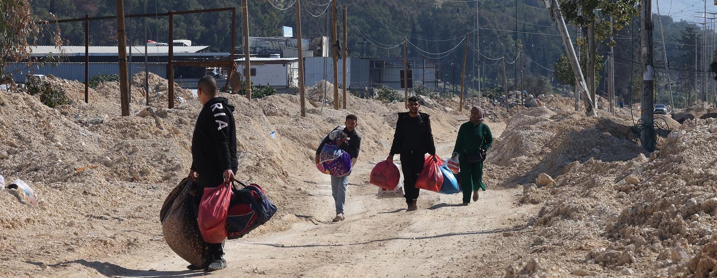 Des familles et des enfants palestiniens transportant leurs biens alors qu'ils évacuent leurs maisons dans le camp de réfugiés de Nur Shams, près de Tulkarem, en Cisjordanie, en raison d'une opération militaire israélienne en cours.