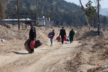 Des familles et des enfants palestiniens transportant leurs biens alors qu'ils évacuent leurs maisons dans le camp de réfugiés de Nur Shams, près de Tulkarem, en Cisjordanie, en raison d'une opération militaire israélienne en cours.