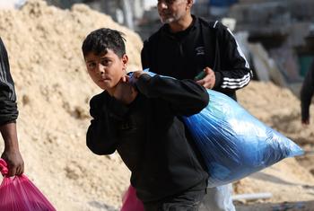 A boy carries possessions as his family leaves their home in Nur Shams refugee camp in the northern West Bank.