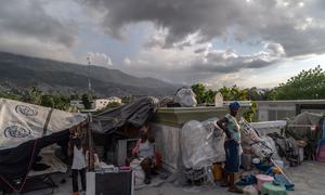 A family displaced by gang violence in  Port-au-Prince, Haiti, lives in a tent on the roof of a former government building.