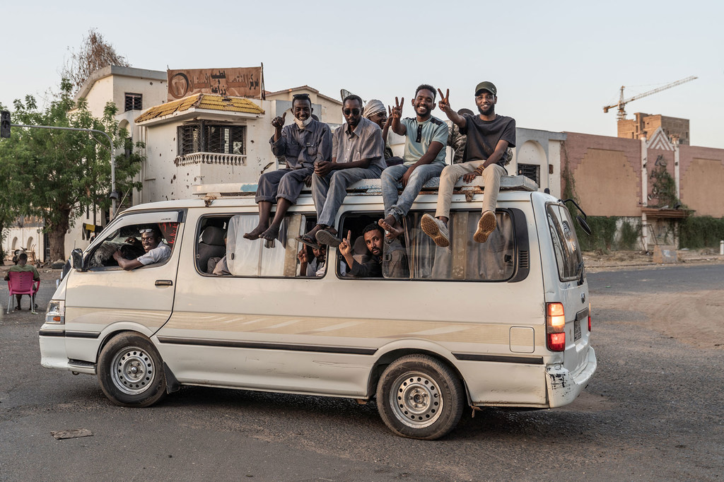 Des jeunes hommes célèbrent la libération d'un quartier de Khartoum en avril 2025.