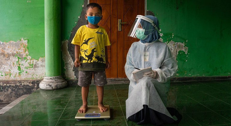 A child is weighed at a community health centre in Central Java province, Indonesia.