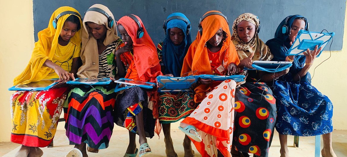 苏丹卡萨拉，几名女童正通过平板电脑和耳机进行远程学习。