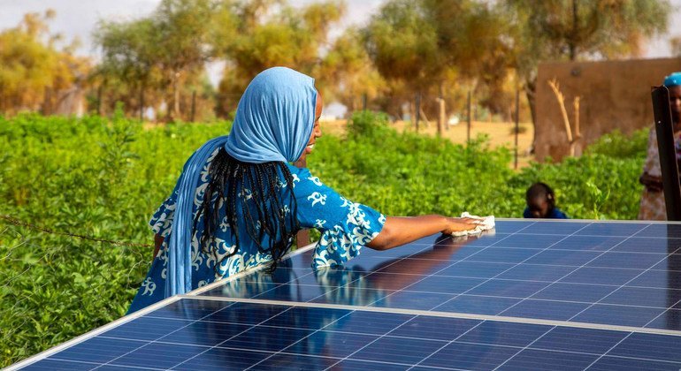 Une femme nettoie un panneau solaire en Mauritanie.