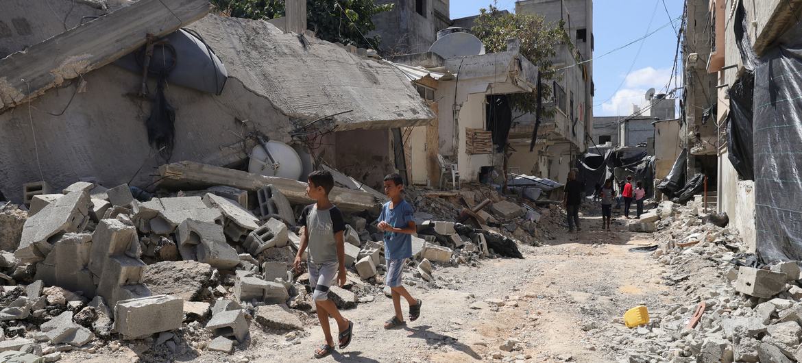 Children and their families flee their homes, walking through the rubble of destroyed roads and buildings in Jenin refugee camp, in the northern West Bank.