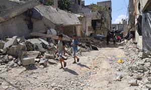 Children and their families flee their homes, walking through the rubble of destroyed roads and buildings in Jenin refugee camp, in the northern West Bank.