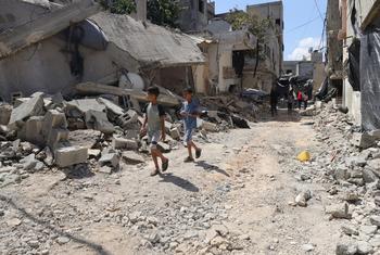 Children and their families flee their homes, walking through the rubble of destroyed roads and buildings in Jenin refugee camp, in the northern West Bank.