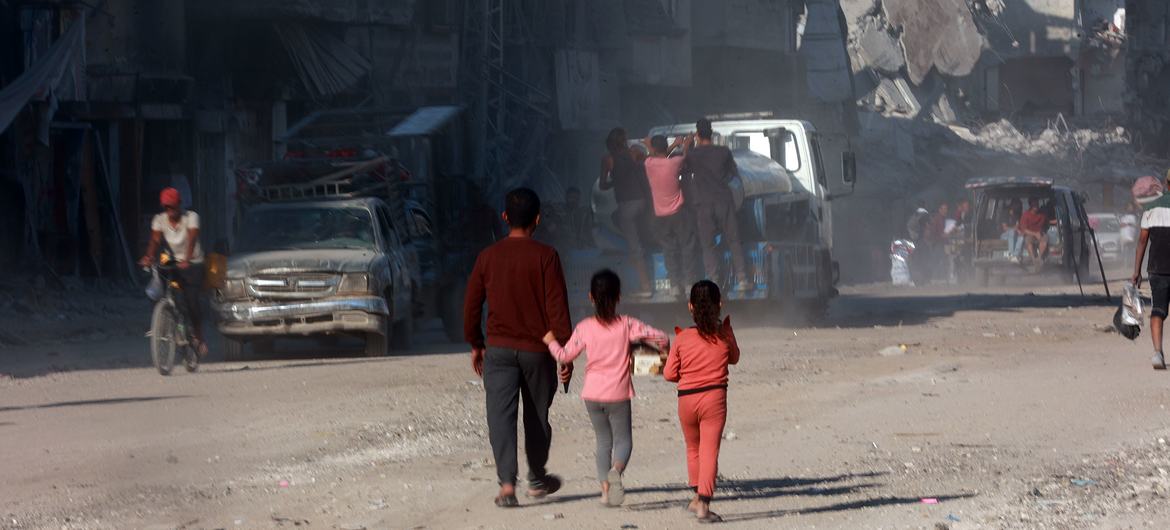A man and two children walk through the devastated streets of Gaza. A man and two children walk through the devastated streets of Gaza.