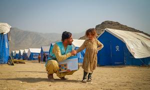 An aid worker talks to a young girl who lives in a camp for displaced people in Afghanistan, close to the Pakistan border.