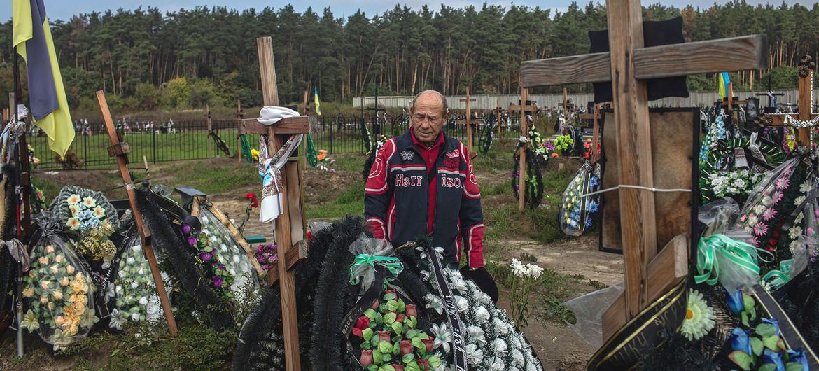 Um homem chora seu melhor amigo falecido em um cemitério em Bucha, Ucrânia.