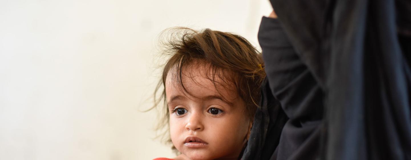 Une mère amène son enfant à une clinique mobile à Hajjah, au Yémen.