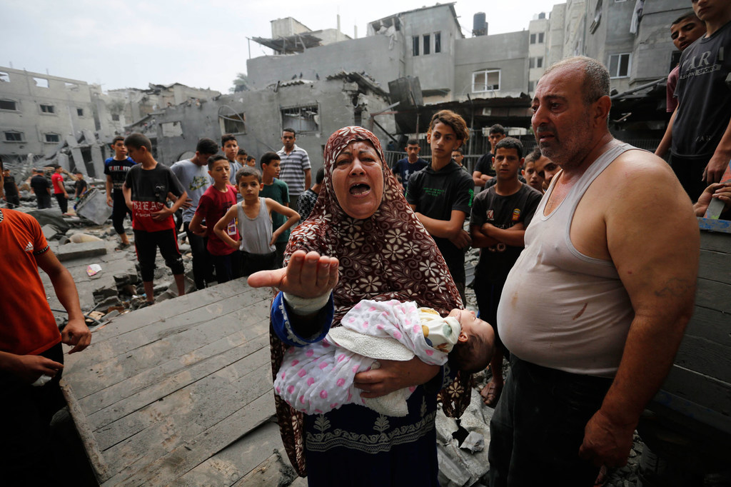 Des familles palestiniennes retournent dans leurs bâtiments lourdement endommagés après des frappes aériennes sur le camp de Nuseirat, à Gaza.