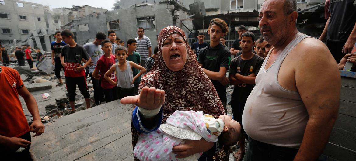 Familias palestinas frente a edificios dañados y destruidos por los bombardeos israelíes a Gaza.