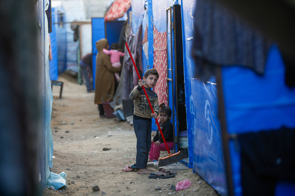 A child cleans a temporary shelter in Gaza.