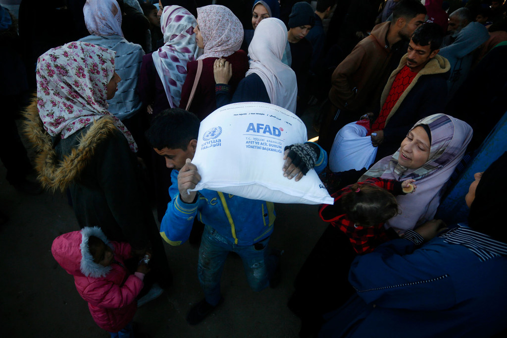 一名加沙男子扛着联合国分发的粮食袋。