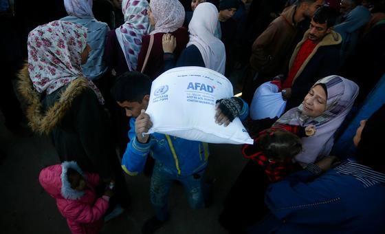 一名加沙男子扛着联合国分发的粮食袋。