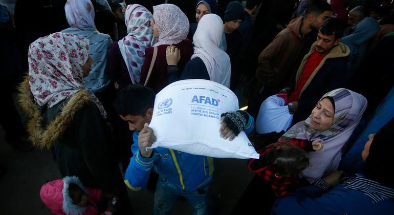 一名加沙男子扛着联合国分发的粮食袋。