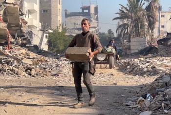 A man removes debris in Gaza.