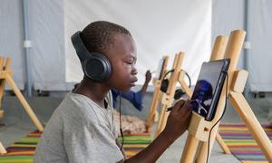 Children participate in an e-learning session at the Al Seniyaa internally displaced people's gathering site in Port Sudan.