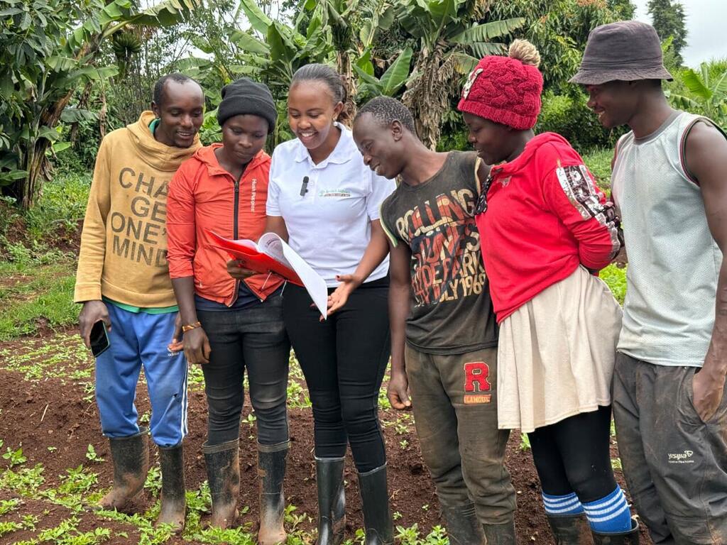 Maryanne Gichanga (centre), a Kenyan agricultural innovator, demonstrates satellite data tools to local farmers.