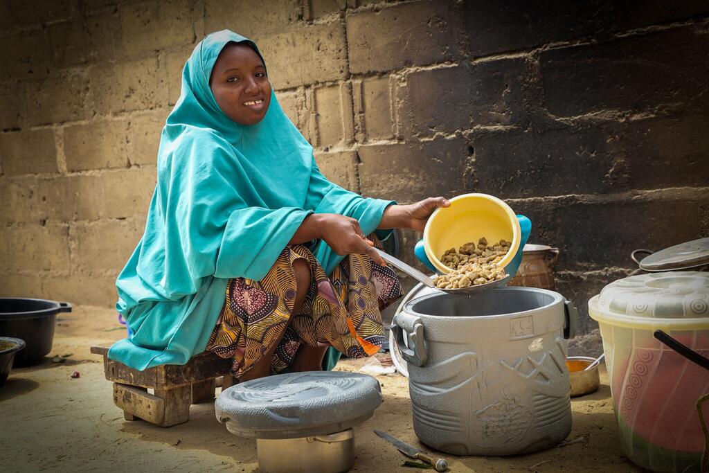 在尼日利亚约贝州，一位受到世界粮食计划署援助的妇女正在为家人准备食物。