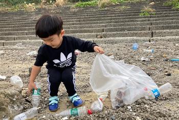 The Sao's youngest son picks up plastic bottles from the beach.