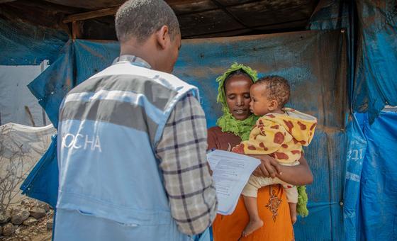 أحد موظفي الأمم المتحدة يتحدث مع والدة طفل يعاني من سوء التغذية في موقع لإيواء النازحين في ميكيلي، في منطقة تيغراي شمال إثيوبيا.