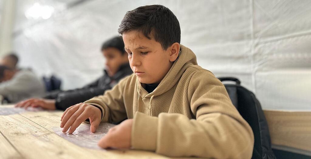 Con el apoyo de la UNRWA, Mohammed, un estudiante de catorce años con discapacidad visual, vuelve a aprender en Braille en el Centro de Rehabilitación para Niños con Discapacidad Visual reabierto en la Franja de Gaza.