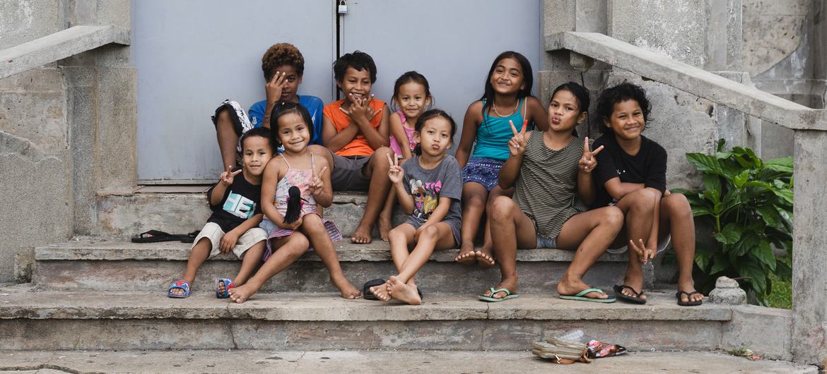 Children pose on the steps of a building in Micronesia.