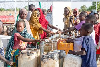 Unos niños recogen agua limpia y potable de una estación instalada por UNICEF en la aldea de Al-Serif, en Darfur.