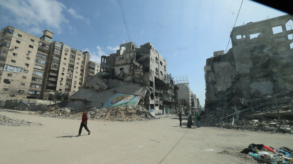 People navigate streets amid rubble and bombed out buildings in Gaza (May, 2025)