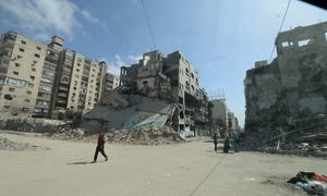 Personas recorren las calles entre escombros y edificios bombardeados en Gaza (mayo de 2025).