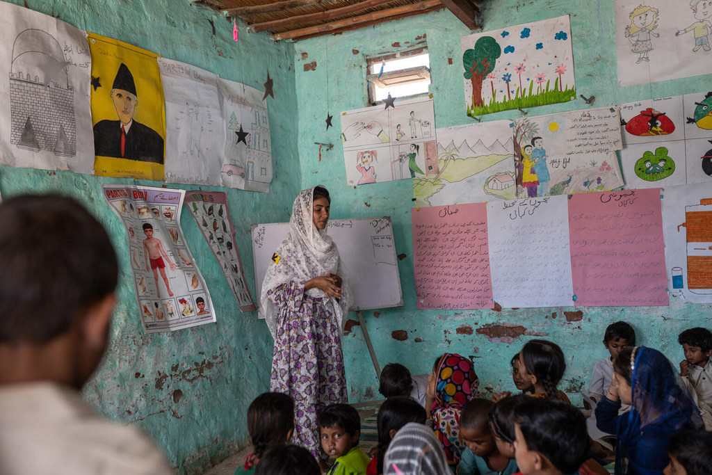 La maestra Shan Zehra se encuentra frente a un aula con niños en un espacio amigable para la infancia apoyado por UNICEF en la provincia de Sindh, Pakistán.