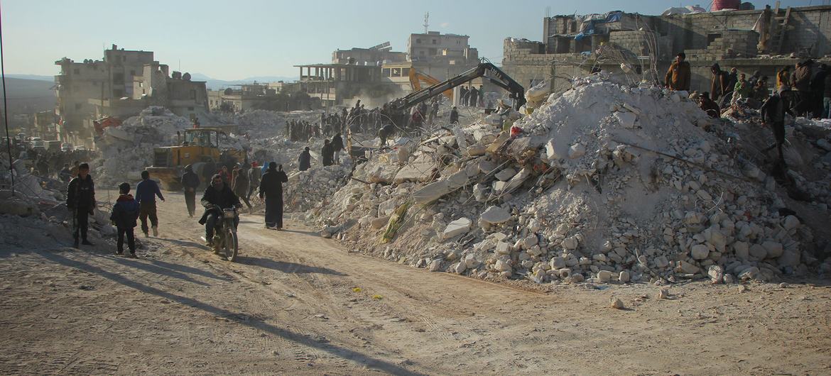 Moradores passam pelos escombros de edifícios desabados em Harém, na Síria, após o terremoto de fevereiro de 2023