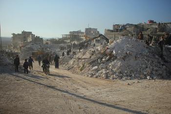 Residents pass the rubble of collapsed buildings in Harem, Syria, following the February 2023 earthquake.