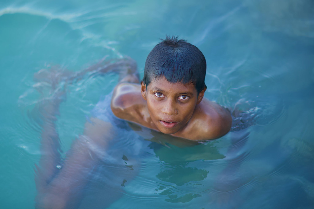 A boy swims in the ocean in the Maldives. Nearly the entire island nation lies less than one meter above sea level, making it highly vulnerable to the impacts of climate change.
