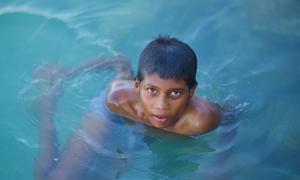 A boy swims in the ocean in the Maldives. Nearly the entire island nation lies less than one meter above sea level, making it highly vulnerable to the impacts of climate change.