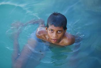 A boy swims in the ocean in the Maldives. Nearly the entire island nation lies less than one meter above sea level, making it highly vulnerable to the impacts of climate change.