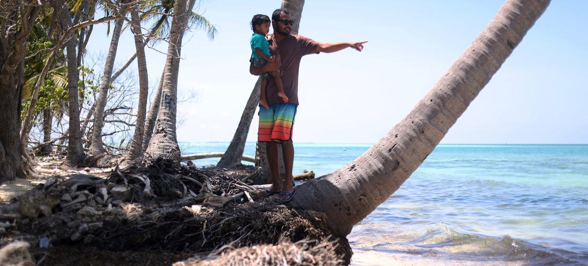 A father and his daughter on a stretch of severely eroded beach in Dhiffushi island, in the Maldives. A father and his daughter on a stretch of severely eroded beach in Dhiffushi island, in the Maldives.