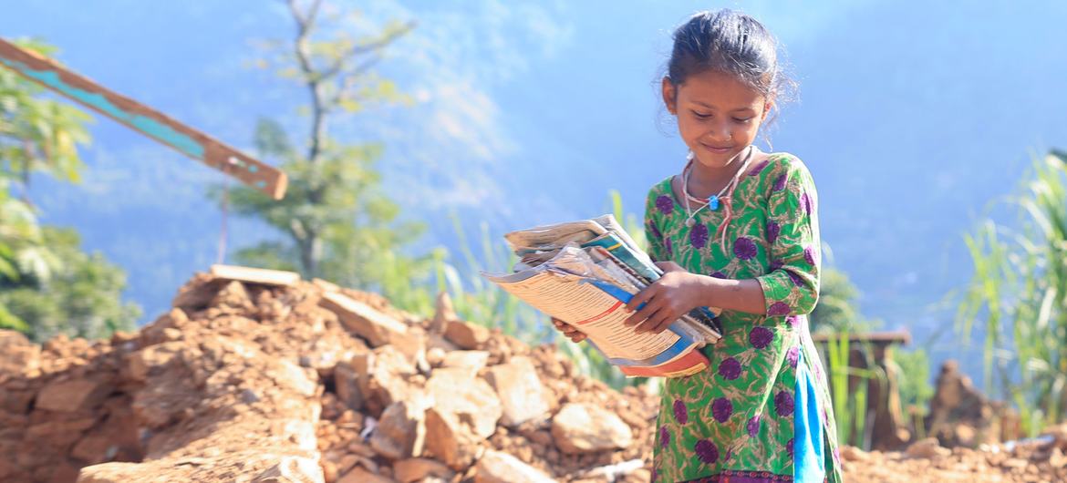 An eight-year-old girl retrieves her textbooks from the rubble of her home, destroyed in an earthquake in western Nepal. An eight-year-old girl retrieves her textbooks from the rubble of her home, destroyed in an earthquake in western Nepal.
