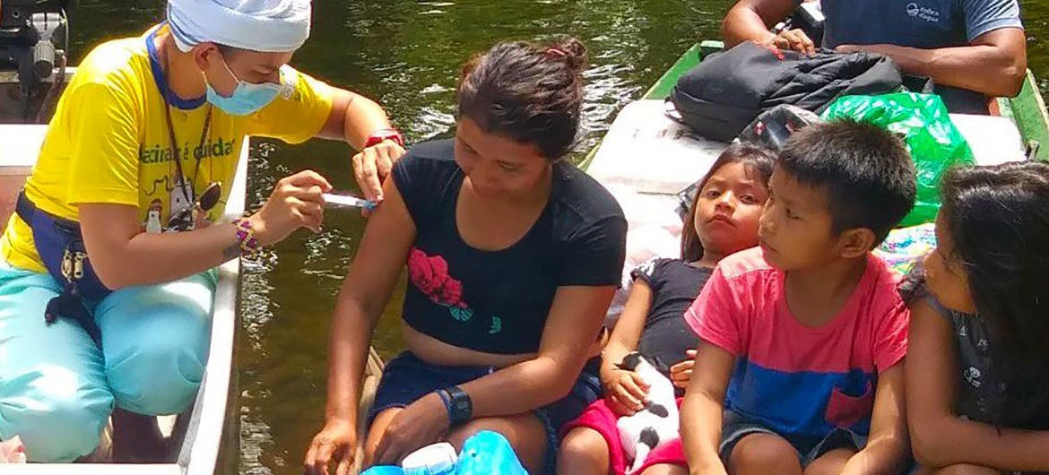 ब्राज़ील के आदिवासी समूह के एक परिवार में महिला को वैक्सीन दी जा रही है.