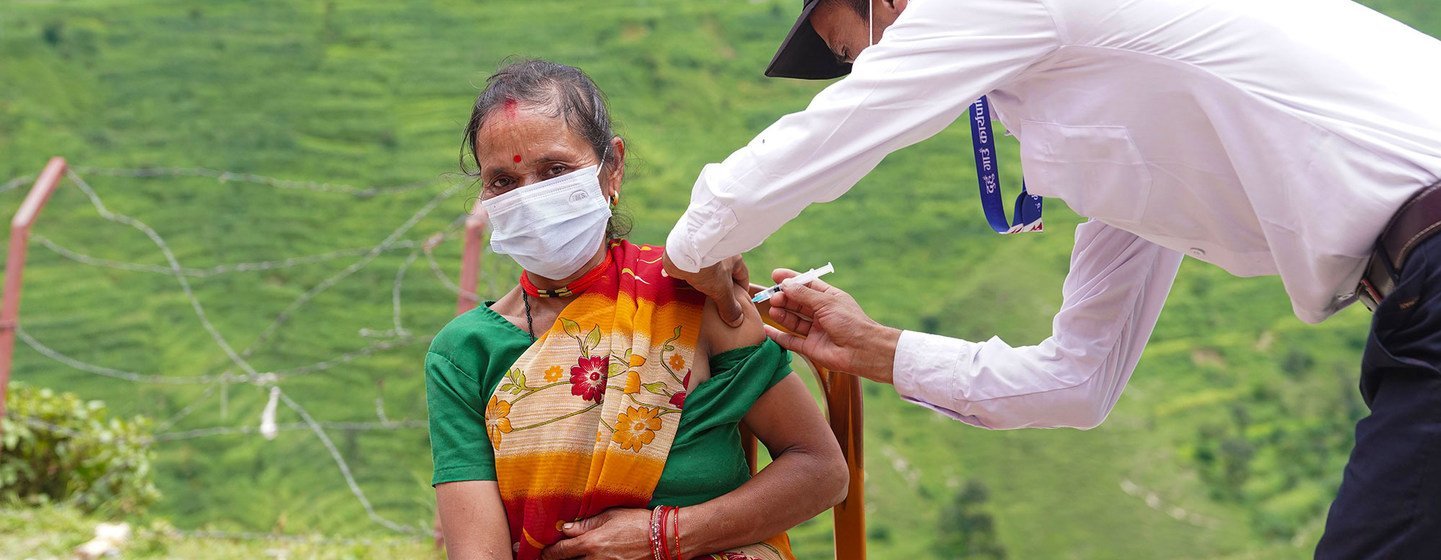 Vacunación de una mujer contra la COVID-19 en un puesto de salud del remoto distrito de Darchula, en Nepal.